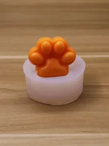 Nahaufnahme der Katzenpfote-Silikonform mit orangefarbenem Schokoladenmousse-Detail