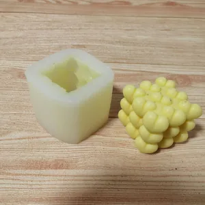 Detailed macro view of a 3D heart cube silicone mold and its finished yellow candle.