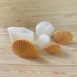 Moules en silicone en forme de coquillage avec bougies finies sur fond bois