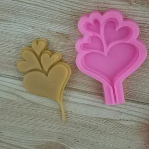 Macro view of heart-shaped tree silicone mold and brown cast chocolate piece for Valentine