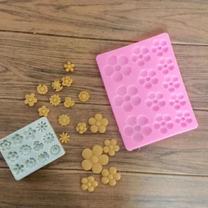 Vista dettagliata degli stampi in silicone con varie forme di margherite e fiori di pasta