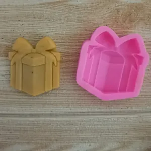 Macro detail of a pink gift box silicone mold alongside a finished yellow craft piece