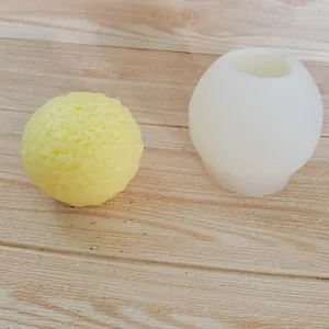 Vista detallada de la vela de bola de rosa amarilla y su molde de silicona blanco DIY