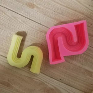 Vue détaillée d'un moule en silicone ondulé irrégulier et d'un produit en plâtre jaune