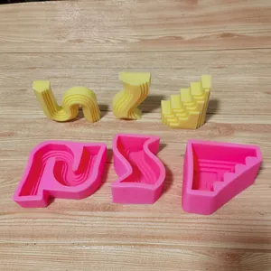Vue détaillée de trois moules en silicone géométriques et échantillons d'artisanat jaunes