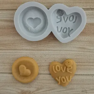 Detail view of heart silicone mold and finished clay hearts with 'Love you' text.