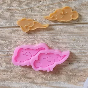 Vista macro di uno stampo in silicone a nuvola con due pezzi di fondant finiti per dolci