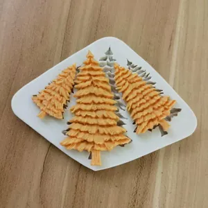 Detailed view of a 3-cavity Christmas tree silicone mold with finished fondant decorations.