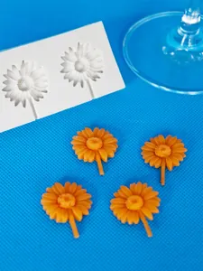 Detail van madeliefje siliconen mal met afgewerkte oranje bloemen knutselstukken