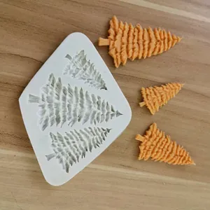 Detail view of white 3-cavity Christmas tree silicone mold and finished orange trees