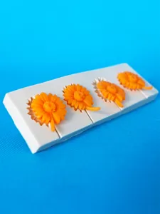 Detailweergave van 4-voudige siliconen vorm voor madeliefjes met oranje fondant bloemen