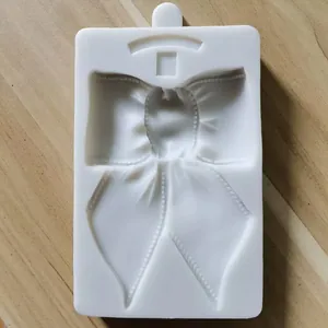 Detailansicht des filigranen Schleifen-Hohlraums einer weißen Silikonform zum Backen.