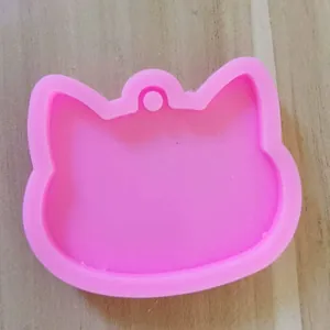Detail view of a pink cat head shaped silicone mold for DIY resin keychains and car pendants