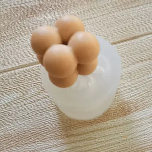 Close-up view of a balloon-shaped silicone mold with a finished brown clay sphere