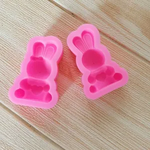 Dettaglio di due stampi in silicone rosa a forma di coniglio con cuore per cioccolato