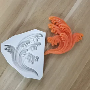 Detailansicht der wellenförmigen Silikonbackform mit einem orangefarbenen Wellenornament