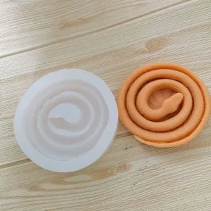 Detailansicht einer gewundenen Schlangen-Silikonform mit orangefarbenem Harzguss