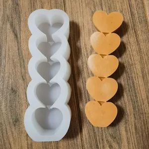 Macro-opname van een witte siliconen mal met 5 hartjes en een oranje wasmonster
