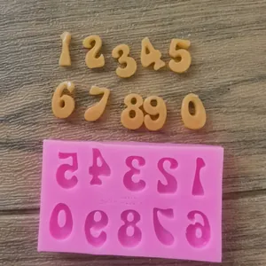 Close-up view of pink silicone number mold with fondant numerical shapes for cakes