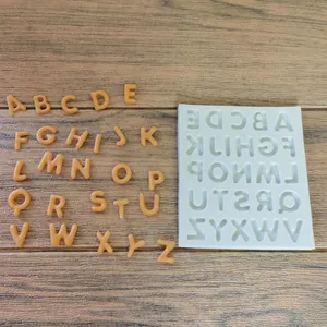 Detailed macro view of white silicone alphabet mold and orange chocolate letters