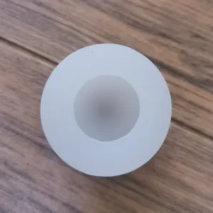 Top macro view of the white 3D egg-shaped silicone mold cavity on wood background.