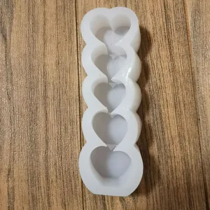 Macro-weergave van een witte siliconen mal met 5-schakels hartvormen voor kaarsen maken.