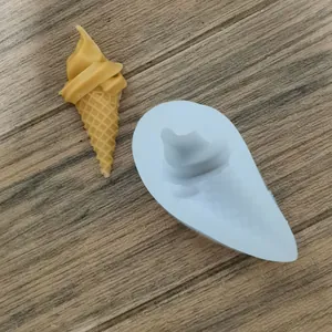 Detail van siliconen ijsjesvorm met een geel voorbeeldmodel op houten tafel