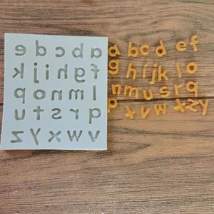 Detailed macro shot showing a lowercase alphabet silicone mold with finished chocolate letters