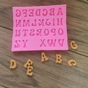 Detailed macro view of pink silicone alphabet mold and finished fondant letters