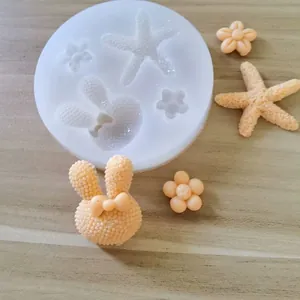 Close-up of starfish and bunny shaped silicone mold with finished peach clay models.