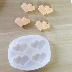 Macro detail of white silicone heart-shaped mold featuring peach-colored clay pieces