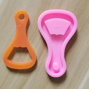 Vue détaillée du moule en silicone rose et du décapsuleur porte-clés en résine orange