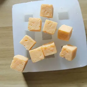 Detail shot of a 9-cavity square silicone mold with textured orange cube casts