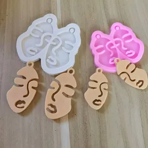 Detailed view of abstract beauty face silicone molds and finished resin keychain charms