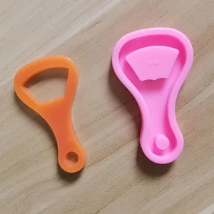 Vue détaillée montrant le moule en silicone rose et l'ouvre-bouteille en résine orange