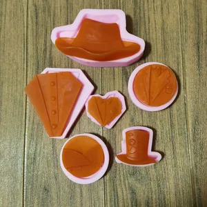 Detailansicht von 6 Silikon-Fondantformen mit Smoking- und Zylinder-Designs.