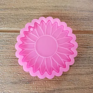 Detalle de un molde de silicona rosa con forma de girasol para llaveros de resina DIY.