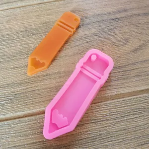 Detailed view of pink pencil-shaped silicone mold and orange resin finished piece
