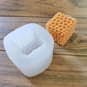 Close-up of a honeycomb cube silicone mold and its finished orange wax candle result.