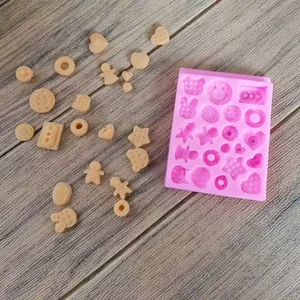 Pink silicone mold for DIY crafts featuring gingerbread man, heart, and donut shapes