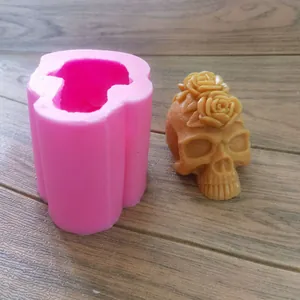 Detail of pink silicone skull mold and finished wax skull with rose decoration