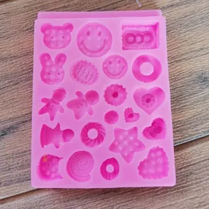 Detailed view of pink silicone mold with gingerbread man, donut, and heart shapes