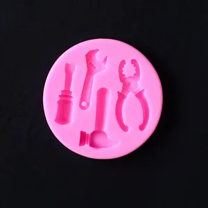Dettaglio dello stampo in silicone rosa con forme di martello, cacciavite e pinze