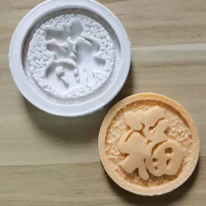 Close-up of a circular silicone mold and a fondant creation featuring the 'Fu' character
