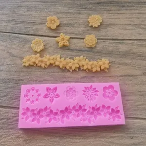 Dettaglio dello stampo in silicone rosa con motivi floreali e decorazioni in fondente