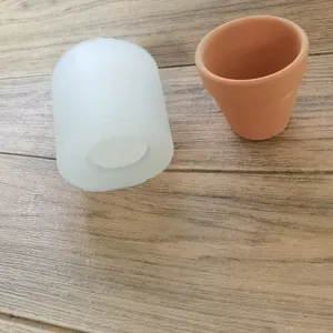 Detailed view of the cylindrical silicone mold and finished mini terracotta flower pot.