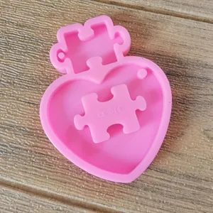 Close-up of pink heart puzzle silicone mold for DIY resin keychains and cookies.