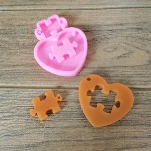 Heart puzzle silicone mold with finished brown resin pieces on wood background