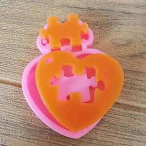 Close-up detail of pink heart puzzle silicone mold with orange finished resin piece