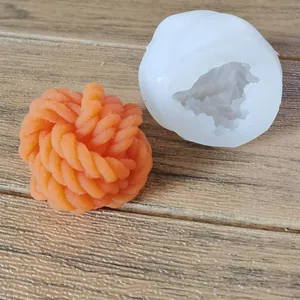 Detailed view of yarn ball silicone mold with finished orange wax creation